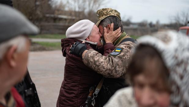 Vrouw en soldaat houden elkaar emotioneel vast tijdens oorlog Oekraïne 
