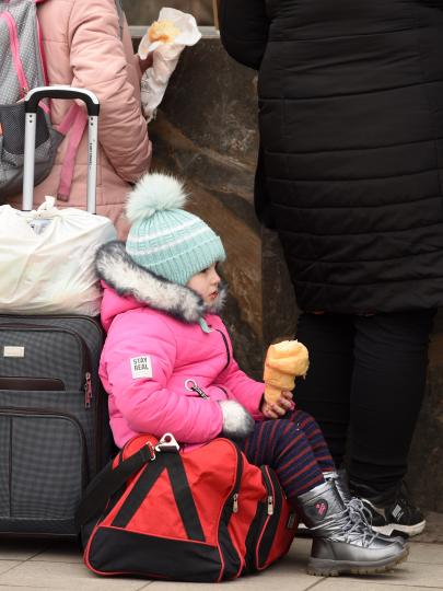 De oorlog in Oekraïne - vluchtelingkind wacht met bagage om zich heen